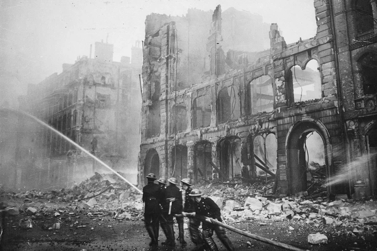 Firemen extinguishing fire from buildings in London after German strike
